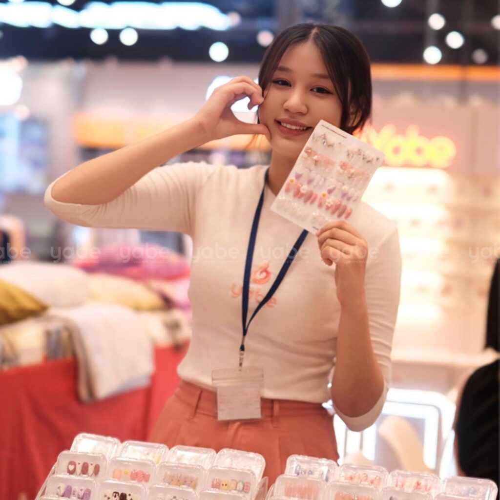 A woman holding a phone and a display of nail polish