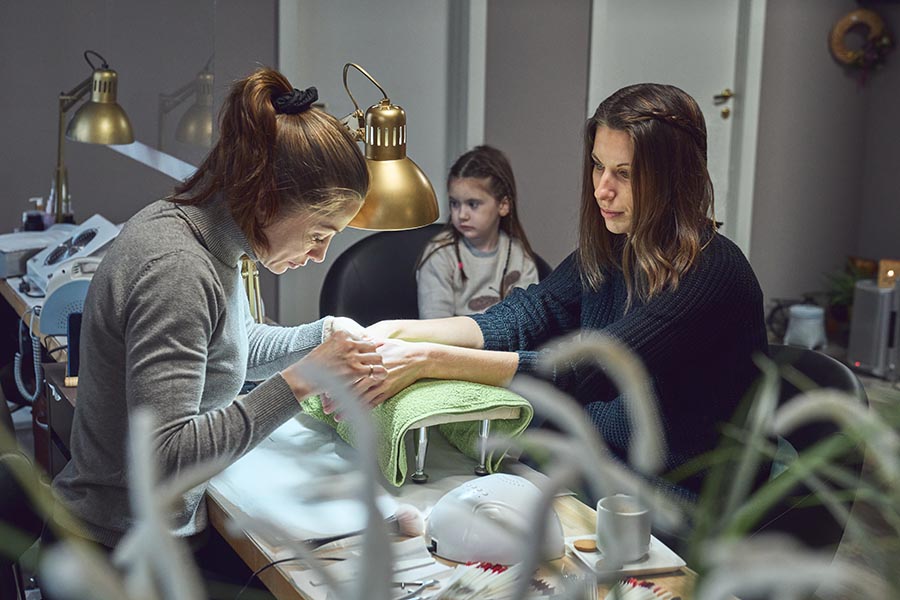 A woman and a girl doing manicure